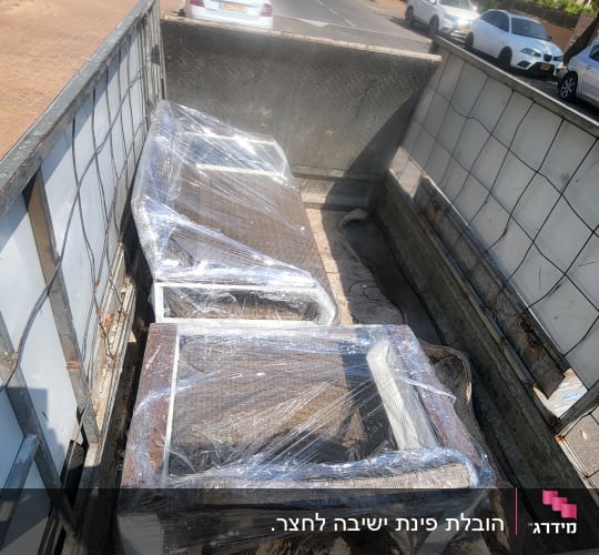 רהיטים עטופים בניילון על משאית הובלה ברחוב עירוני